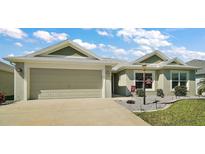 Charming single-story home featuring a two-car garage and landscaped front yard under a bright, cloudy sky at 2175 Cannon Loop, The Villages, FL 32163