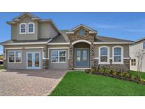 Charming two-story home features stone accents, arched entry, and well-manicured lawn at 2176 Keystone Pass Blvd, Minneola, FL 34715