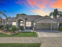 Charming home featuring a three-car garage, mature landscaping, and a welcoming front porch at 25545 Laurel Valley Rd, Leesburg, FL 34748