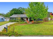 Charming single-story home featuring a lush lawn, beautiful landscaping, and cozy seating area at 375 N Boyd St, Winter Garden, FL 34787