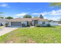 Charming single-story home with a well-manicured lawn and attached garage at 10257 Dovehill Ln, Clermont, FL 34711