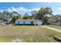 Charming single-story home with two-tone paint, a well-manicured lawn, and mature trees at 11987 Se 95Th Ter, Belleview, FL 34420
