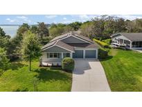 Beautiful single-Gathering home with a well-manicured lawn, two-car garage, and a view of the lake at 137 E Palmetto Ave, Howey In The Hills, FL 34737