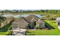 An attractive home features a three-car garage, mature landscaping, and is situated on a picturesque lot with water views at 1723 Carrera Dr, The Villages, FL 32159