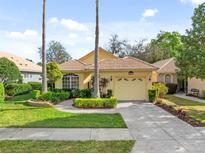 Charming single-story home featuring a tile roof, two-car garage, and well-manicured landscaping at 9027 Saint Andrews Way, Mount Dora, FL 32757