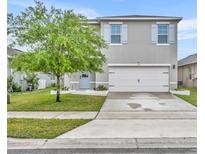 Charming two-story home features a well-manicured lawn, light blue shutters, and a two-car garage at 113 Camilla Rd, Deland, FL 32724