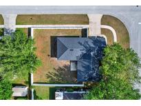 Aerial view of a home with a well-maintained roof, fenced yard, and mature trees at 1313 Lake Idamere Blvd, Tavares, FL 32778