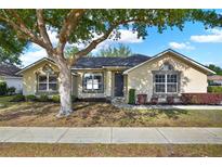 Charming single-story home features a well-manicured lawn, mature tree, and a welcoming entryway, creating a cozy curb appeal at 1313 Lake Idamere Blvd, Tavares, FL 32778