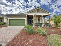 Charming single-Gathering home with a well-manicured lawn, a covered porch, and an attached garage, enhancing its curb appeal at 135 Crepe Myrtle Dr, Groveland, FL 34736