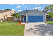 Charming single-story home featuring a blue garage door and well-maintained front lawn at 1566 Lawndale Cir, Winter Park, FL 32792