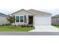 Charming single-story home featuring a manicured lawn, neutral siding, and an attached two-car garage at 1914 Hux Ct, The Villages, FL 34762