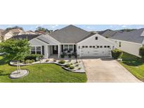 Well-maintained home with charming landscaping, manicured lawn, and welcoming curb appeal at 1940 Dempsey Ln, The Villages, FL 32163