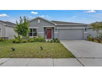 Charming single-story home with a well-manicured lawn and a two-car garage at 4905 Vellacito Way, Davenport, FL 33897