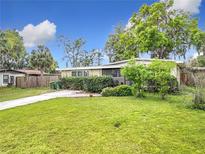 Landscaped front yard with green lawn and mature trees offers inviting curb appeal at 515 Scenic St, Leesburg, FL 34748