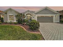 Charming single-story home with a well-manicured lawn and a brick-paved driveway at 685 Winifred Way, The Villages, FL 32162