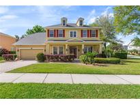 Charming two-story home featuring a manicured lawn, red shutters, and a welcoming front porch at 1001 Harmony Ln, Clermont, FL 34711