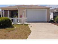 Charming single-story home with a two-car garage and well-maintained lawn at 1420 Fairway St, The Villages, FL 32162
