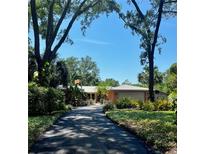 Charming single Gathering home featuring a long driveway, beautiful landscaping, and a large garage at 2121 Suzanne Dr, Mount Dora, FL 32757