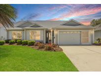 Charming single-story home with a well-manicured lawn, beautiful landscaping, and a two-car garage at 2204 Margarita Dr, The Villages, FL 32159