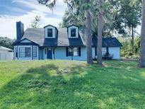 Charming two-story home featuring a front yard, classic siding, and a welcoming entrance at 33710 Linda Ln, Leesburg, FL 34748