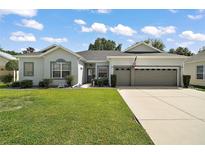 Charming single-story home featuring a well-manicured lawn and an attached two-car garage at 3800 Woodleaf Ct, Leesburg, FL 34748