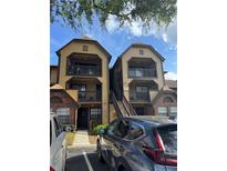 Apartment complex with balconies, stairs, and parking area with neutral tones and brick accents at 420 Forestway Cir # 206, Altamonte Springs, FL 32701
