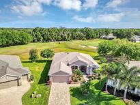 Stunning aerial view of a home showcasing lush landscaping and a beautiful golf course backdrop on a sunny day at 4247 James River Cir, Leesburg, FL 34748