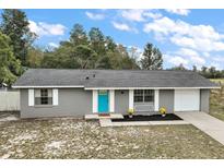 Charming single-story home featuring a bright blue front door and well-maintained landscaping at 425 Marion Oaks Dr, Ocala, FL 34473