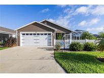 Charming single-story home featuring a two-car garage, screened lanai, and well-maintained landscaping at 463 Kayla Ct, The Villages, FL 32163