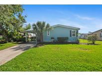 Charming single-story home featuring a lush green lawn, carport, and mature palm tree at 501 Santa Fe Rd, Tavares, FL 32778