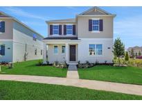 Charming two-story home with manicured lawn and inviting entrance, showcasing curb appeal at 5173 Waypointe Blvd, Apopka, FL 32712