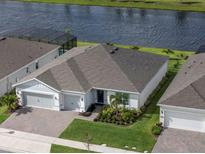 Beautiful home with a well-manicured lawn near a lake and screened in porch is captured in an aerial shot at 6308 Mossy Oak Rd, St Cloud, FL 34771