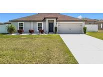 Charming single-Gathering home with a well-manicured lawn, inviting entryway, and two-car garage at 11995 Callicarpa Ln, Leesburg, FL 34788