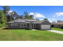 Charming single-story home with well-maintained lawn, attached garage and modern solar panels at 12817 Sw 77Th Cir, Ocala, FL 34473