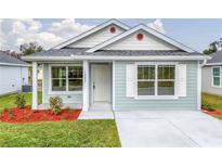 Charming single-story home with light blue siding, a well-manicured lawn, and a welcoming front entrance at 1282 Cottage Cir, Tavares, FL 32778
