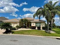 Charming home with lush landscaping, mature palms, and a well-maintained lawn at 2071 Westchester Way, The Villages, FL 32162