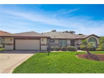 Charming single-story home featuring a well-maintained lawn and an attached two-car garage at 5408 Queen Victoria Dr, Leesburg, FL 34748