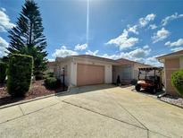 Charming single-story home featuring a two-car garage, mature landscaping, and a well-maintained lawn at 728 Ramirez Ave, The Villages, FL 32159