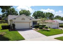 Charming single-story home features a brick driveway and meticulously landscaped front yard, and attached two-car garage at 860 Wolf Creek St, Clermont, FL 34711