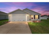 Charming single-story home with a two-car garage and well-maintained landscaping at 12054 Ne 51St Cir, Oxford, FL 34484