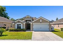 Charming single-story home featuring a well-manicured lawn and an attached two-car garage at 15501 Markham Dr, Clermont, FL 34714