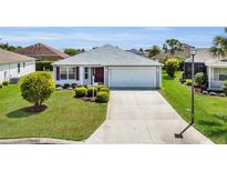 Charming single-story home with well-maintained landscaping and an inviting front yard at 3203 Islawild Way, The Villages, FL 32163