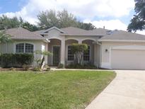 Beautiful single-story home with a well-manicured lawn, arched entryway, and a two-car garage at 605 Westview Dr, Minneola, FL 34715