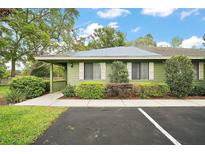 Charming home exterior with green siding, white shutters, landscaped bushes and well maintained yard and parking at 638 Mount Homer Rd # 3-C, Eustis, FL 32726