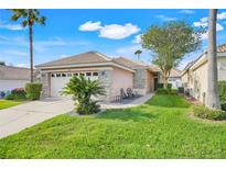 Charming home featuring a well-manicured lawn, a two-car garage, and beautiful landscaping at 9081 Saint Andrews Way, Mount Dora, FL 32757