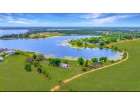 Aerial view of a lakeside home with a sprawling lawn and beautiful water access at 9510 Suggs Rd, Clermont, FL 34711