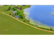 Expansive lakefront property featuring a well-maintained home, large metal building, and a private dock for serene lakeside living at 9510 Suggs Rd, Clermont, FL 34711