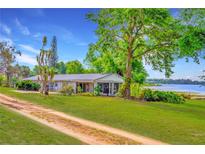 Charming single-story home with a well-maintained lawn and beautiful lake views at 9510 Suggs Rd, Clermont, FL 34711