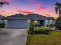 Charming single-story home featuring a well-manicured lawn and a two-car garage, perfect for suburban living at 1346 Kilgore Way, The Villages, FL 32163