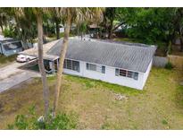 Charming single story home with carport and white exterior and blue shutters at 1406 Spartan Ave, Leesburg, FL 34748
